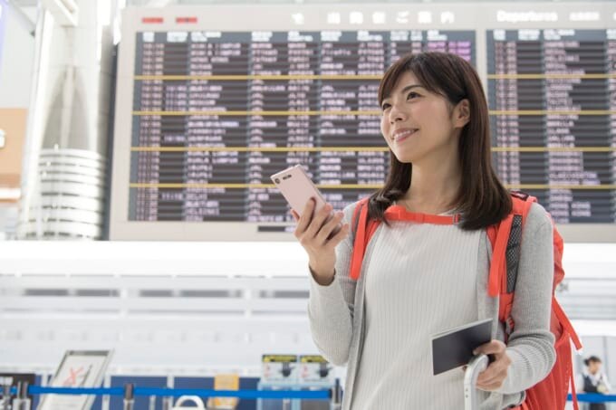 成田空港タイムボードと女性