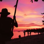 サンセットのビーチを眺める女の人